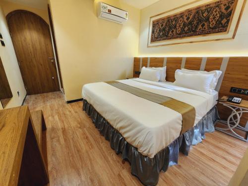 a bedroom with a large bed in a room at Hotel Nova Bopal in Bodakdev