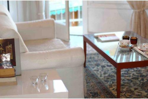 a living room with a white couch and a coffee table at Casa Serenella - Bilocale a due passi dal mare in Sanremo