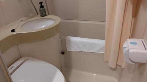 een kleine badkamer met een wastafel en een toilet bij Tsuyama Central Hotel Townhouse in Tuyama