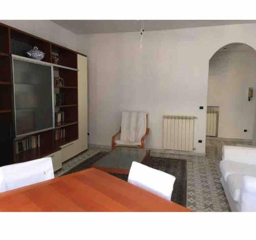 a living room with a table and chairs and a television at Casa Serenella - Bilocale a due passi dal mare in Sanremo