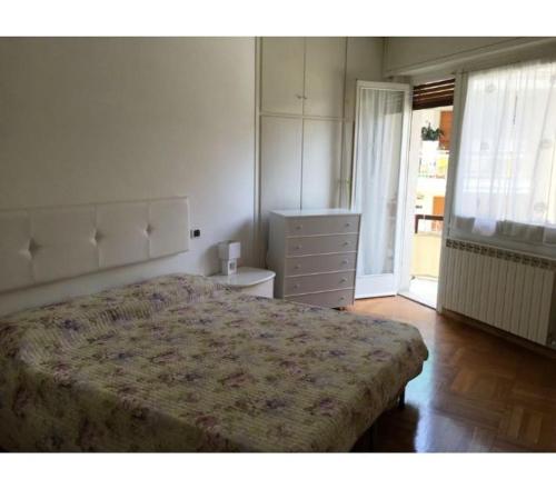 a bedroom with a large bed and a dresser at Casa Serenella - Bilocale a due passi dal mare in Sanremo