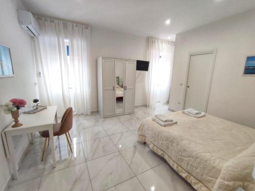 1 dormitorio con cama, mesa y escritorio en Tina’s Room en Santa Maria di Castellabate