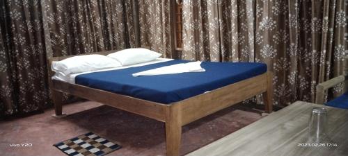 The Andaman Sunset View Resort في ميناء بلير: سرير عليه أغطية زرقاء ومخدات بيضاء