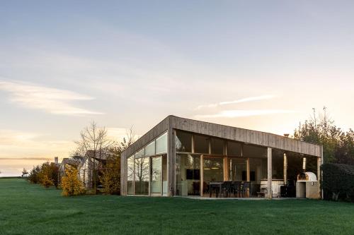 a glass house with a lawn in front of it at Landgoed Moerslag in Sint Geertruid