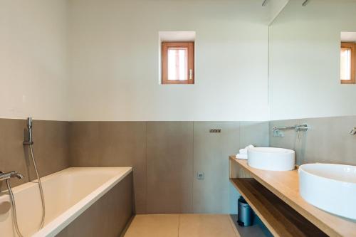 a bathroom with a tub and a sink at Landgoed Moerslag in Sint Geertruid