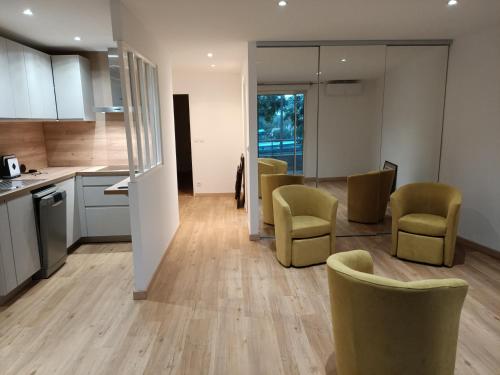 eine Küche und ein Wohnzimmer mit Stühlen und einem Tisch in der Unterkunft Très belle vue Canal du Midi in Béziers