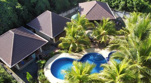 an aerial view of a house with a swimming pool and palm trees at Tyner's Place in Panglao