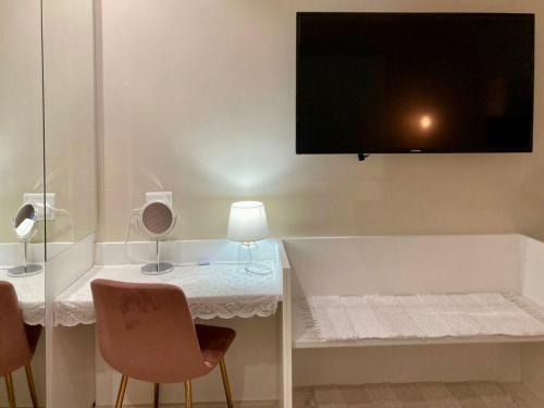 a room with a table with chairs and a tv on the wall at The Ranch Guesthouse in Potchefstroom