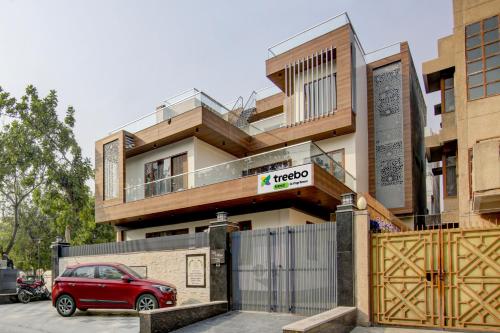 a red car parked in front of a house at Treebo Trend Sai Village - Manesar in Gurgaon