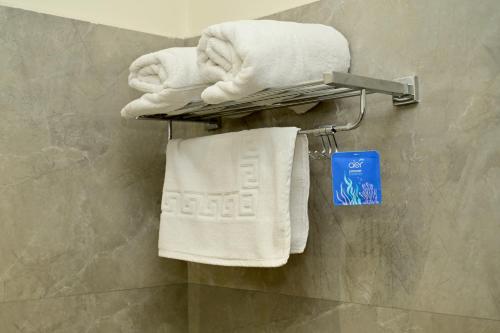 Ein Haufen Handtücher auf einem Handtuchhalter im Badezimmer in der Unterkunft The Amber hotel in Ambikāpur