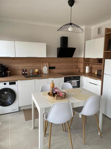 a kitchen with a white table and white chairs at Une escapade au cœur d'Annecy in Annecy