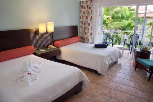 a hotel room with two beds and a balcony at VH - Gran Ventana Beach Resort in San Felipe de Puerto Plata