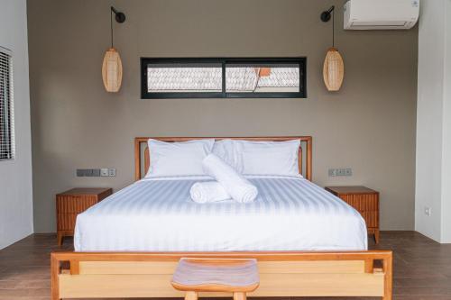 una camera da letto con un letto con due asciugamani bianchi di ASRI CINTA VILLA ad Ubud