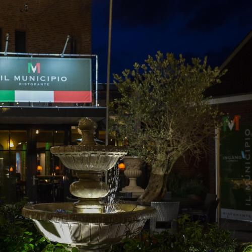 a fountain in front of a building at night at Hotel De Schout in Denekamp