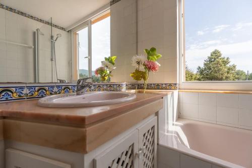 bagno con lavandino, vasca e finestra di Villa can torrent a San Jose de sa Talaia