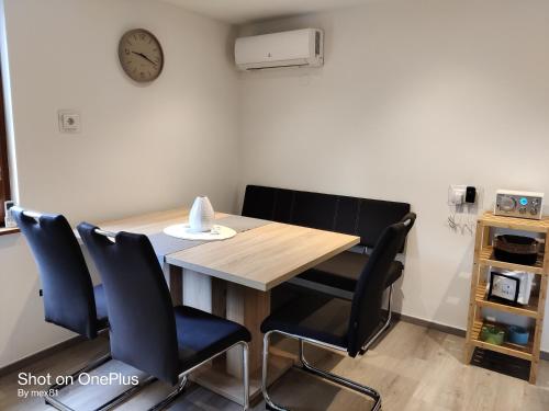 a dining room table with chairs and a clock on the wall at Ferienwohnung Grete, an der Weinstraße in Ehrenhausen