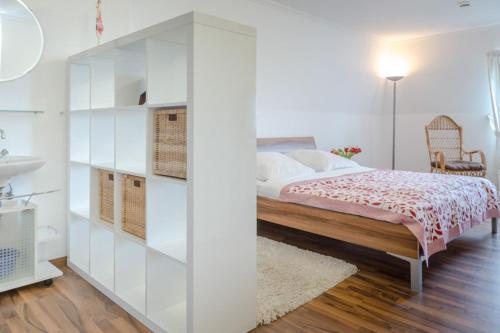 een witte slaapkamer met een bed en een wastafel bij Vik1_23 in Westerland