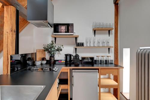 a kitchen with a black counter top and wooden cabinets at City & Old Town View Rooftop by Downtown Apartments in Gdańsk