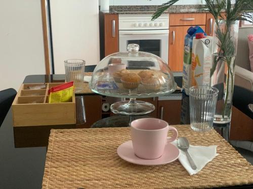 una mesa con una taza de café y un tazón de magdalenas en Apartamento con encanto y mucha luz, en Villaviciosa