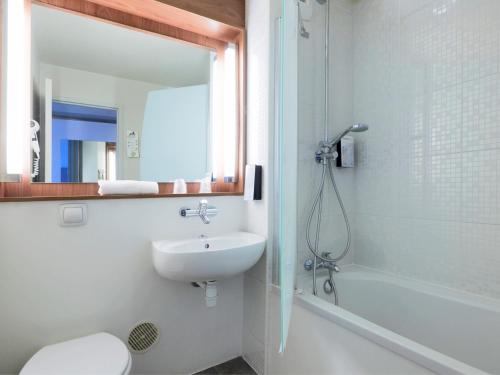 ein Bad mit einem Waschbecken, einer Dusche und einem WC in der Unterkunft Campanile Villeneuve-Sur-Lot in Villeneuve-sur-Lot