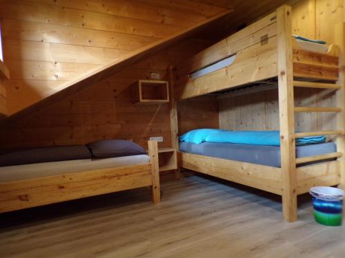 a bedroom with two bunk beds in a log cabin at Ferienwohnung Moharblick 2 in Großkirchheim