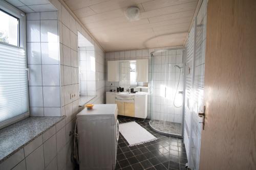 a white bathroom with a sink and a shower at Ferienwohnung für 2 Personen mit direktem Zugang in Auw