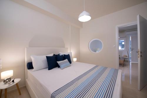 a bedroom with a large bed with blue and white pillows at Creta Vivere Villas in Agia Pelagia