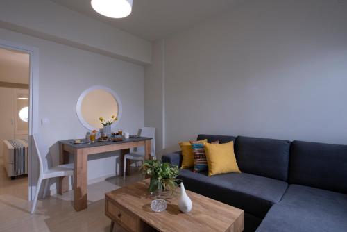 a living room with a blue couch and a table at Creta Vivere Villas in Agia Pelagia