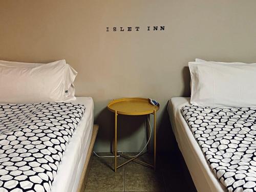 two beds next to each other with a table between them at Puli Islet Inn in Puli
