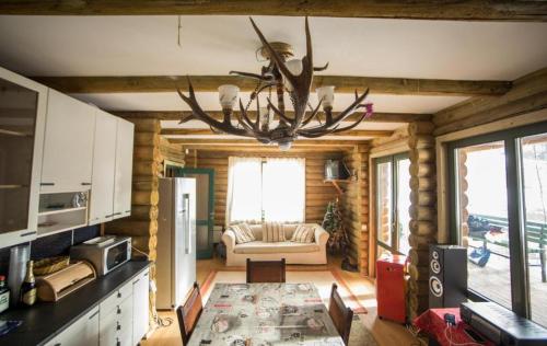 a living room with a chandelier in a log cabin at Cabana La Panţiru in Văleni-Stînişoara