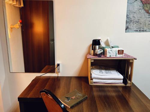 a room with a desk with a chair and a mirror at Puli Islet Inn in Puli