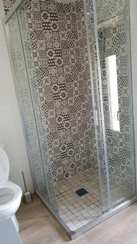 a bathroom with a shower with a tile wall at Leutoño in Malpica