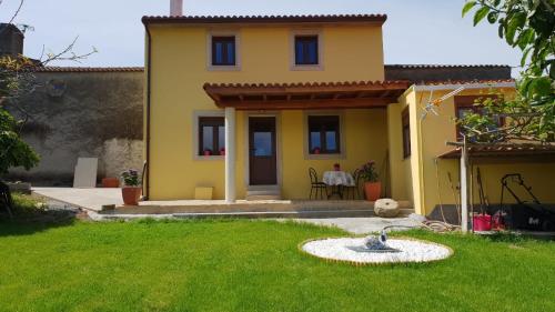 ein gelbes Haus mit einem Brunnen im Hof in der Unterkunft Leutoño in Malpica