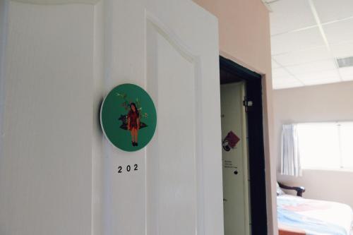 a clock on a wall next to a bedroom at Puli Islet Inn in Puli