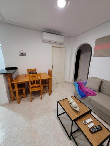 - un salon avec un canapé et une table dans l'établissement Apartamento bajo con terraza y piscina, à Torrevieja