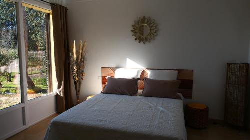 een slaapkamer met een bed en een groot raam bij LE PATIO in Sarrians