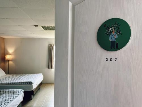 a room with two beds and a clock on the wall at Puli Islet Inn in Puli