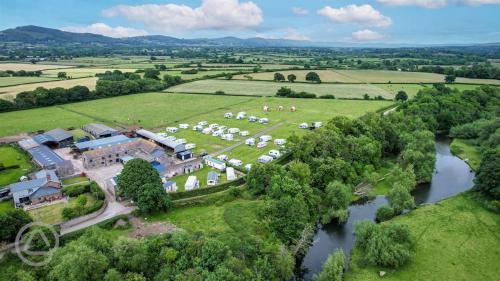 an aerial view of a mansion with a river at Abbey farm luxury glamping in Rhuddlan