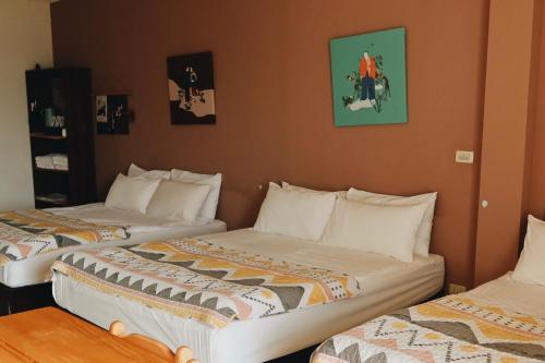two beds in a hotel room with two at Puli Islet Inn in Puli