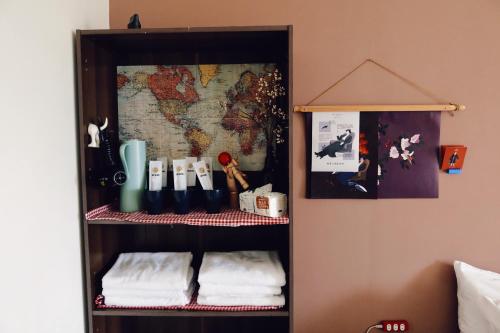 a book shelf with towels and a map on the wall at Puli Islet Inn in Puli