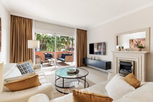 a living room with white furniture and a fireplace at Apartamento La Perla in Marbella