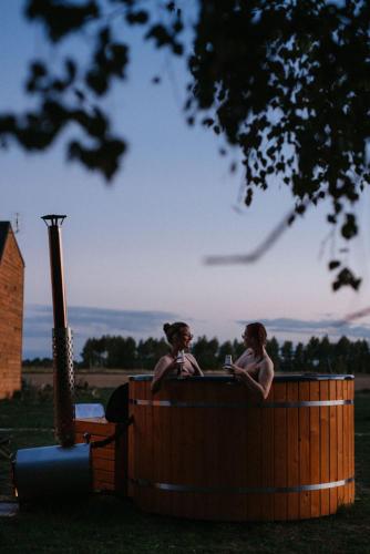 two people are sitting in a hot tub at Apartamenty Domek na Roztoczu in Horyniec Zdrój