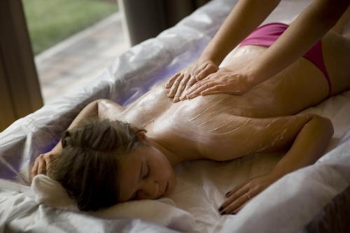 a little girl laying on a bed getting a massage at Bio Hotel Brusago Vital & Wellness in Bedollo