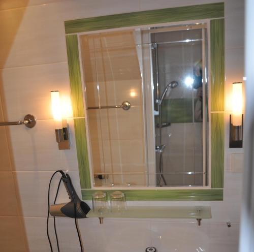 y baño con ducha con espejo y cámara. en Bauernhof Haim, en Pichl bei Aussee