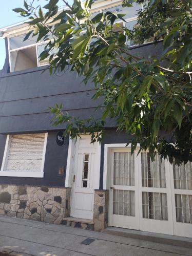 a blue house with white doors and windows at El Bicho Negro Hostel in Concordia