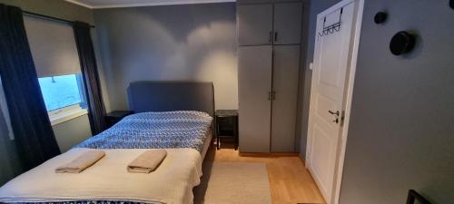 a small bedroom with two beds and a window at Lund - Exellent Apartment in Tromsø