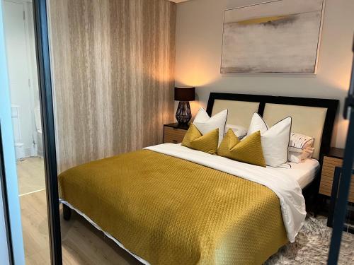 a bedroom with a large bed with a yellow blanket at Ellipse Apartment in Midrand