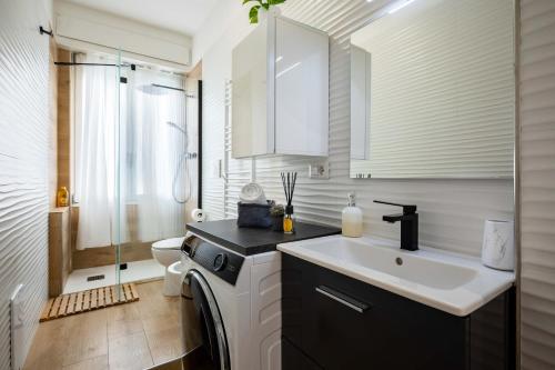 La salle de bains est pourvue d'un lavabo et d'un lave-linge. dans l'établissement Affori House, à Milan
