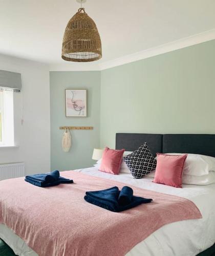 a bedroom with a large bed with two blue towels on it at May Cottage - Heart of Vibrant Village & 10 mins Walk to Beach in Milford on Sea