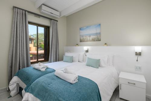 a bedroom with two beds and a window at San Lameer Villa 2828 - 3 Bedroom Superior - 6 pax - San Lameer Rental Agency in Southbroom